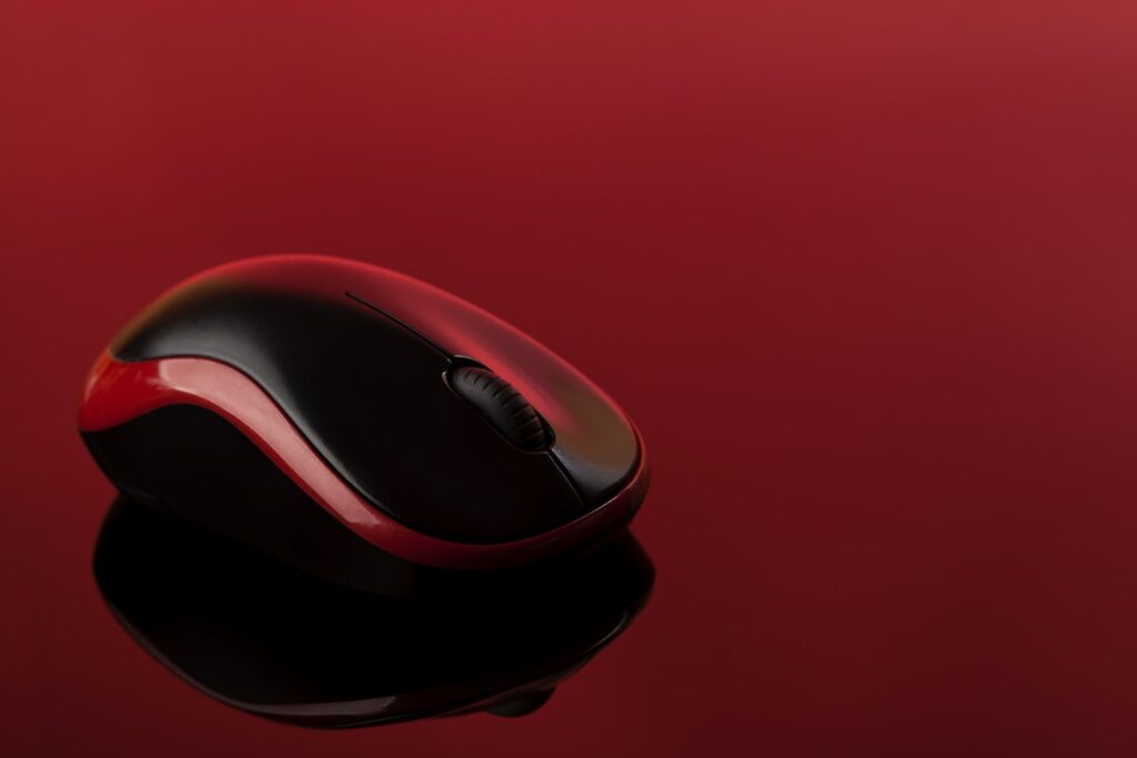 a red and black computer mouse on a red surface